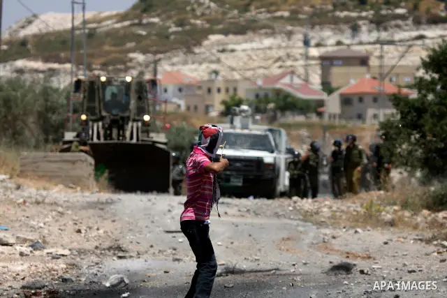 Palestinian protesters hurl a stones at Israeli soldiers during a demonstration against the expropriation of Palestinian land by Israel in the village of Kafr Qaddum, near the West Bank city of Nablus on June 1, 2012. Ph...