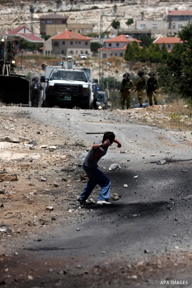 Palestinian protesters hurl a stones at Israeli soldiers during a demonstration against the expropriation of Palestinian land by Israel in the village of Kafr Qaddum, near the West Bank city of Nablus on June 1, 2012. Ph...
