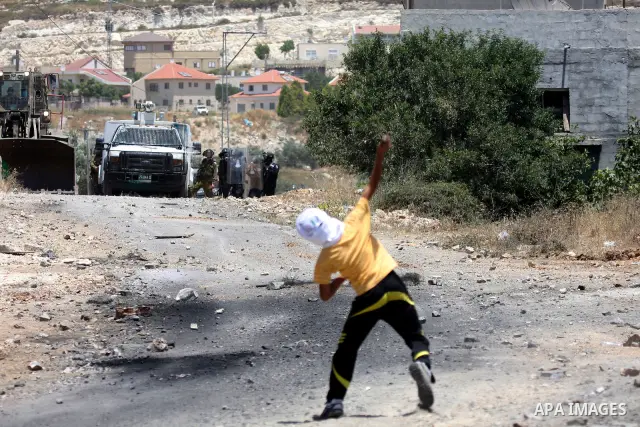 Palestinian protesters hurl a stones at Israeli soldiers during a demonstration against the expropriation of Palestinian land by Israel in the village of Kafr Qaddum, near the West Bank city of Nablus on June 1, 2012. Ph...