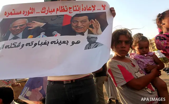 Egyptian protesters hold placards against the presidential candidate Ahmed Shafik during a demonstration in Tahrir Square decrying the result of the first round of voting in the Egyptian presidential election in Cairo, E...