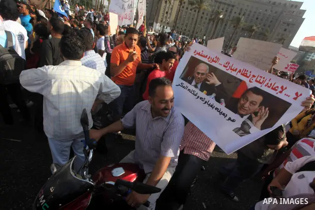 Egyptian protesters hold placards against the presidential candidate Ahmed Shafik during a demonstration in Tahrir Square decrying the result of the first round of voting in the Egyptian presidential election in Cairo, E...