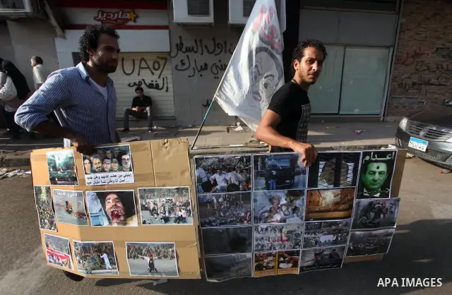 Egyptian protesters hold placards against the presidential candidate Ahmed Shafik during a demonstration in Tahrir Square decrying the result of the first round of voting in the Egyptian presidential election in Cairo, E...