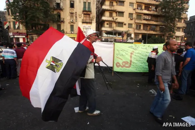 Egyptian protesters hold national flag during a demonstration against Egyptian presidential candidate Ahmed Shafiq in Tahrir Square decrying the result of the first round of voting in the Egyptian presidential election i...