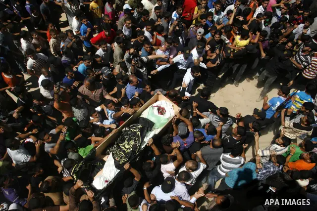 Palestinians carry a flag-covered coffin containing the body of gunman Ahmed Nassir in Khan Younis in the southern Gaza Strip June 2, 2012. Nassir broke into Israel on Friday and killed a soldier before being shot dead h...