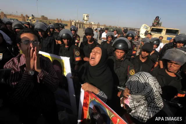 Egyptians Anti-Mubarak protester holding poster depicting youth killed during the uprising, reacts after a court sentenced deposed president Hosni Mubarak to life in prison, outside the police academy in Cairo, Egypt, 02...