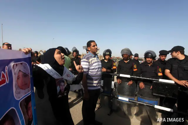 Egyptians Anti-Mubarak protester holding poster depicting youth killed during the uprising, reacts after a court sentenced deposed president Hosni Mubarak to life in prison, outside the police academy in Cairo, Egypt, 02...