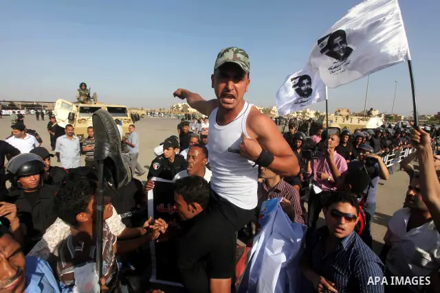 Egyptians Anti-Mubarak protester holding poster depicting youth killed during the uprising, reacts after a court sentenced deposed president Hosni Mubarak to life in prison, outside the police academy in Cairo, Egypt, 02...