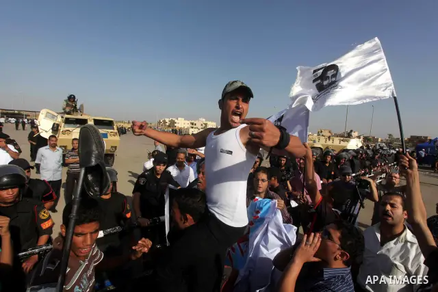 Egyptians Anti-Mubarak protester holding poster depicting youth killed during the uprising, reacts after a court sentenced deposed president Hosni Mubarak to life in prison, outside the police academy in Cairo, Egypt, 02...