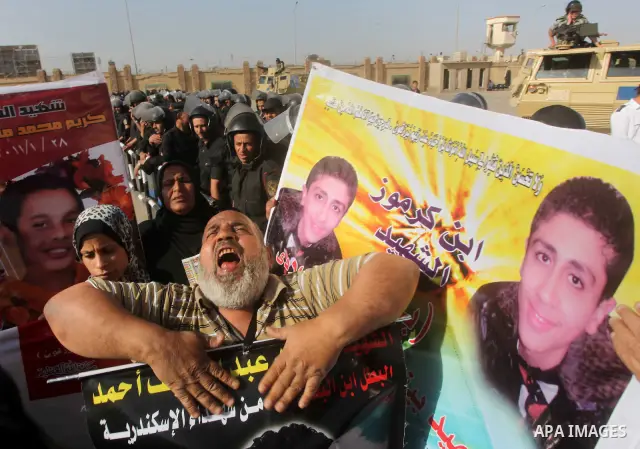 Egyptians Anti-Mubarak protester holding poster depicting youth killed during the uprising, reacts after a court sentenced deposed president Hosni Mubarak to life in prison, outside the police academy in Cairo, Egypt, 02...