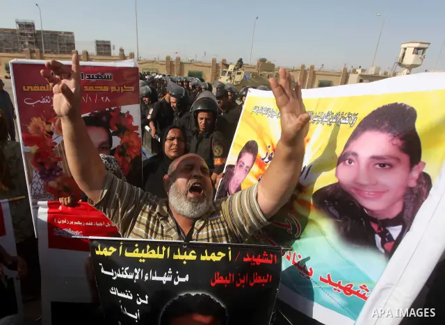 Egyptians Anti-Mubarak protester holding poster depicting youth killed during the uprising, reacts after a court sentenced deposed president Hosni Mubarak to life in prison, outside the police academy in Cairo, Egypt, 02...