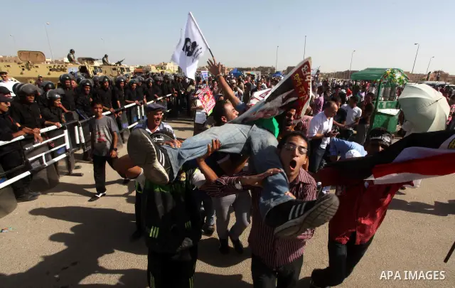 Egyptians Anti-Mubarak protester holding poster depicting youth killed during the uprising, reacts after a court sentenced deposed president Hosni Mubarak to life in prison, outside the police academy in Cairo, Egypt, 02...