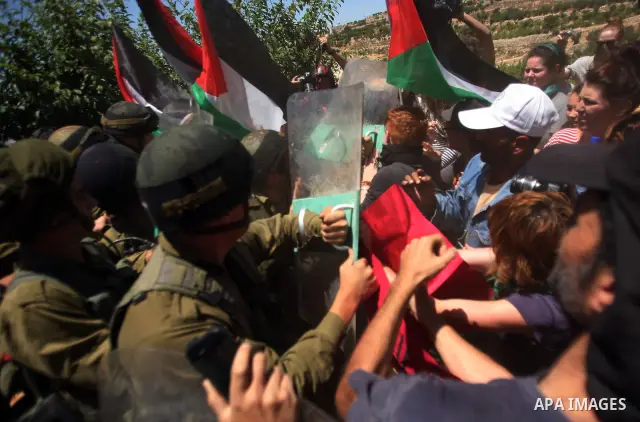 Israeli soldiers prevent Palestinians, left-wing Israeli and foreign peace activists from heading towards the Jewish settlement of Karim Tsor to protest against the confiscation of Palestinian land from the West Bank vil...