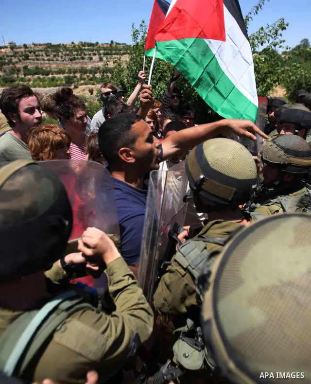 Israeli soldiers prevent Palestinians, left-wing Israeli and foreign peace activists from heading towards the Jewish settlement of Karim Tsor to protest against the confiscation of Palestinian land from the West Bank vil...