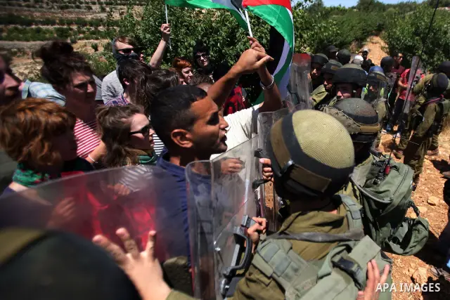 Israeli soldiers prevent Palestinians, left-wing Israeli and foreign peace activists from heading towards the Jewish settlement of Karim Tsor to protest against the confiscation of Palestinian land from the West Bank vil...