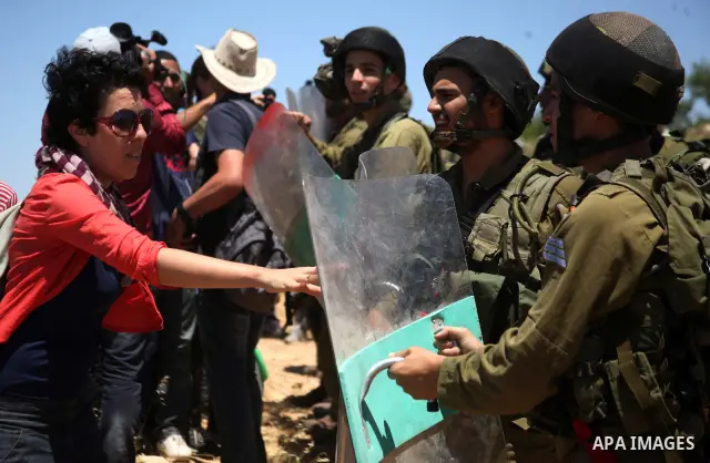Israeli soldiers prevent Palestinians, left-wing Israeli and foreign peace activists from heading towards the Jewish settlement of Karim Tsor to protest against the confiscation of Palestinian land from the West Bank vil...