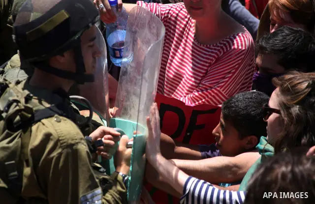 Israeli soldiers prevent Palestinians, left-wing Israeli and foreign peace activists from heading towards the Jewish settlement of Karim Tsor to protest against the confiscation of Palestinian land from the West Bank vil...