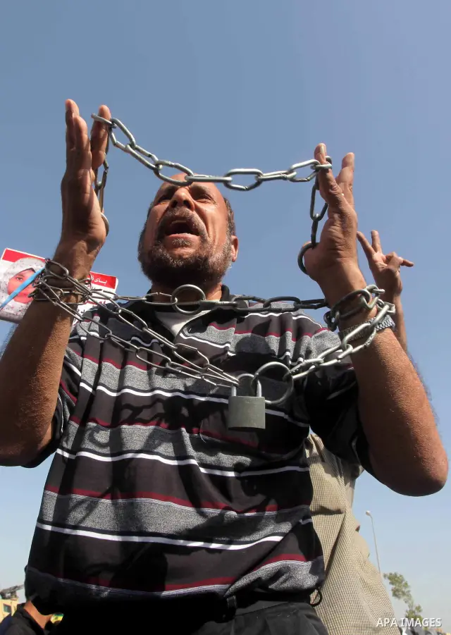 Egyptians Anti-Mubarak protester holding poster depicting youth killed during the uprising, reacts after a court sentenced deposed president Hosni Mubarak to life in prison, outside the police academy in Cairo, Egypt, 02...