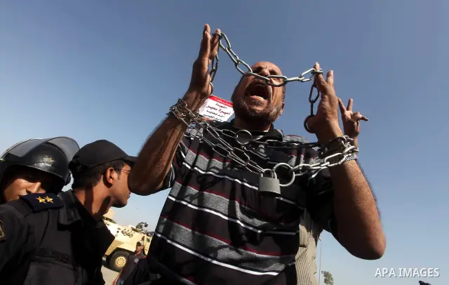 Egyptians Anti-Mubarak protester holding poster depicting youth killed during the uprising, reacts after a court sentenced deposed president Hosni Mubarak to life in prison, outside the police academy in Cairo, Egypt, 02...