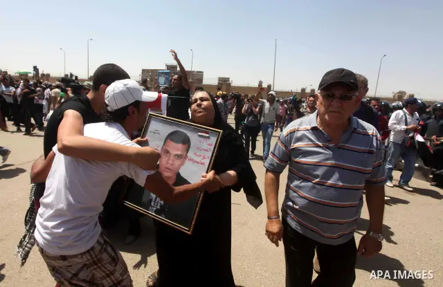 Egyptians Anti-Mubarak protester holding poster depicting youth killed during the uprising, reacts after a court sentenced deposed president Hosni Mubarak to life in prison, outside the police academy in Cairo, Egypt, 02...