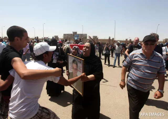 Egyptians Anti-Mubarak protester holding poster depicting youth killed during the uprising, reacts after a court sentenced deposed president Hosni Mubarak to life in prison, outside the police academy in Cairo, Egypt, 02...