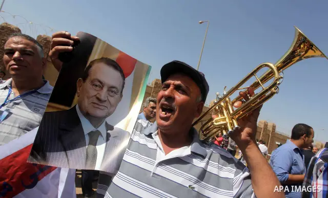 Supporters of deposed president Hosni Mubarak react after a court sentenced him to life in prison, outside the police academy where the court is located in Cairo June 2, 2012. Mubarak was sentenced to life in prison on S...