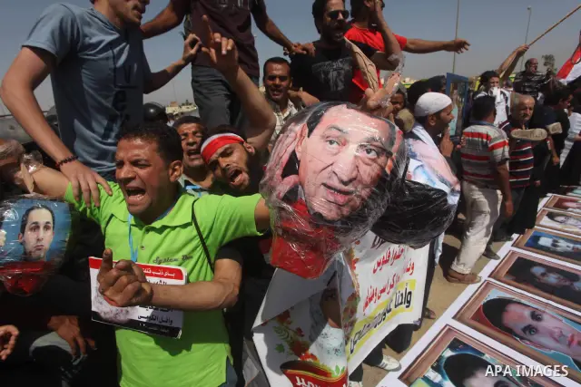 Egyptians Anti-Mubarak protester holding poster depicting youth killed during the uprising, reacts after a court sentenced deposed president Hosni Mubarak to life in prison, outside the police academy in Cairo, Egypt, 02...