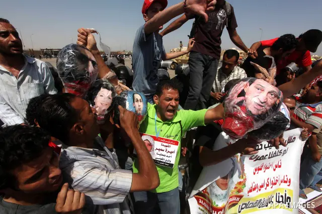Egyptians Anti-Mubarak protester holding poster depicting youth killed during the uprising, reacts after a court sentenced deposed president Hosni Mubarak to life in prison, outside the police academy in Cairo, Egypt, 02...