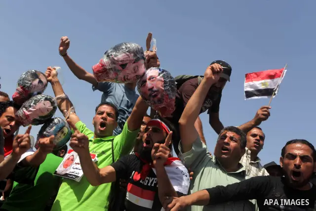 Egyptians Anti-Mubarak protester holding poster depicting youth killed during the uprising, reacts after a court sentenced deposed president Hosni Mubarak to life in prison, outside the police academy in Cairo, Egypt, 02...