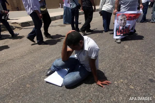 Supporters of deposed president Hosni Mubarak react after a court sentenced him to life in prison, outside the police academy where the court is located in Cairo June 2, 2012. Mubarak was sentenced to life in prison on S...