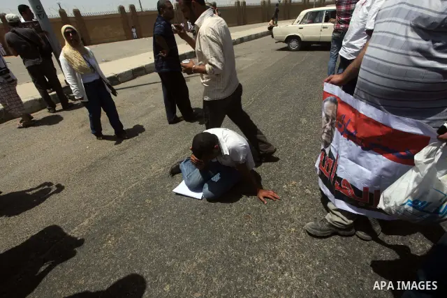 Supporters of deposed president Hosni Mubarak react after a court sentenced him to life in prison, outside the police academy where the court is located in Cairo June 2, 2012. Mubarak was sentenced to life in prison on S...