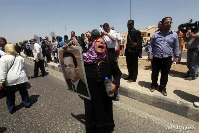 Supporters of deposed president Hosni Mubarak react after a court sentenced him to life in prison, outside the police academy where the court is located in Cairo June 2, 2012. Mubarak was sentenced to life in prison on S...