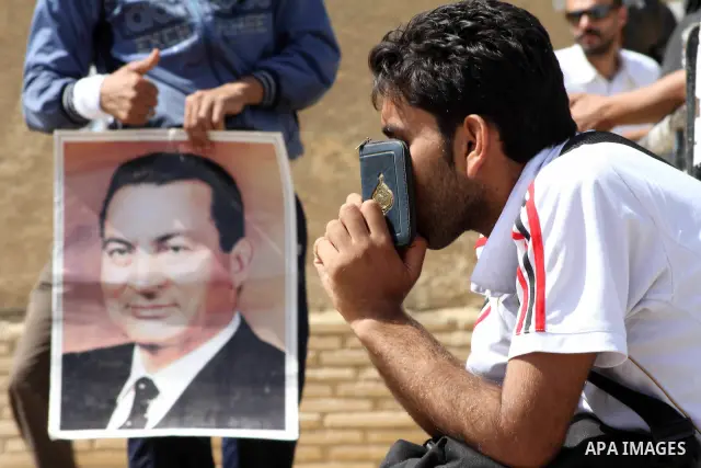 Supporters of deposed president Hosni Mubarak react after a court sentenced him to life in prison, outside the police academy where the court is located in Cairo June 2, 2012. Mubarak was sentenced to life in prison on S...