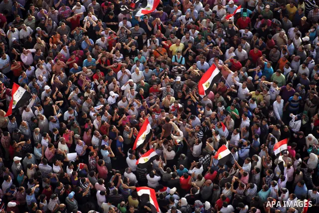 A view taken from a building overviewing Tahrir square shows Egyptian protesters shouting slogans against former President Hosni Mubarak and his aides during a demonstration hours after the announcement of the verdict in...