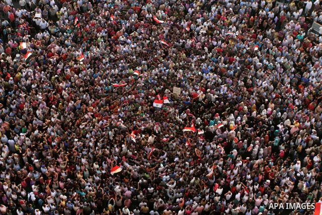 A view taken from a building overviewing Tahrir square shows Egyptian protesters shouting slogans against former President Hosni Mubarak and his aides during a demonstration hours after the announcement of the verdict in...