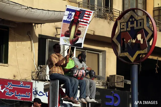 Egyptian protesters hold their national flag and effigies of the heads of former President Hosni Mubarak and his sons during a protest hours after the announcement of the verdict in their trial, in Tahrir square, Cairo,...