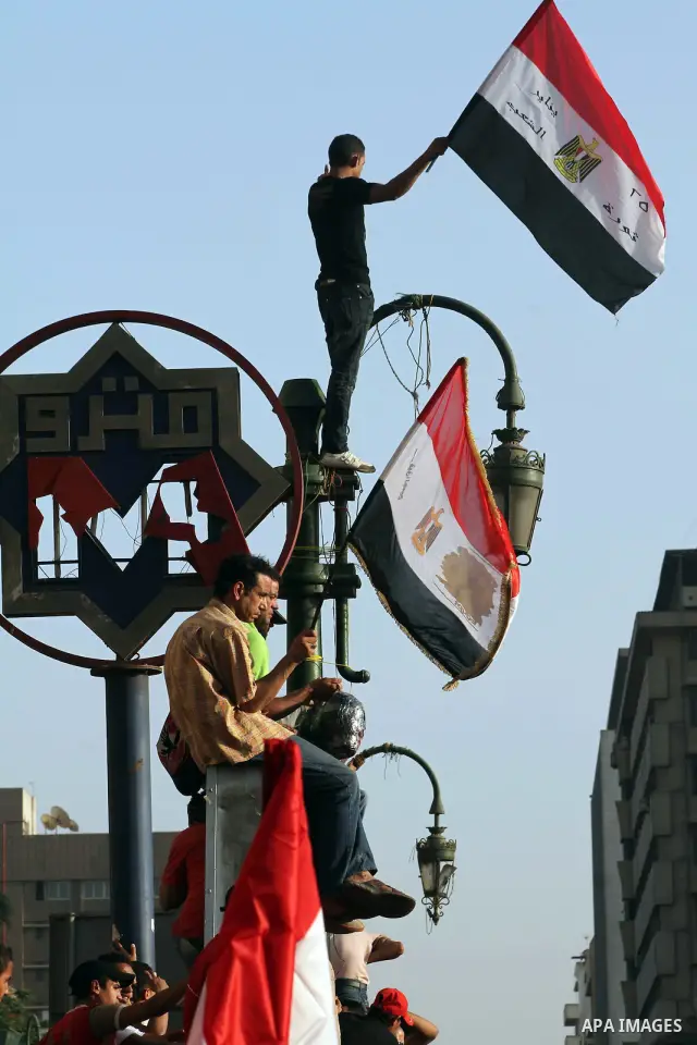 Egyptian protesters hold their national flag and effigies of the heads of former President Hosni Mubarak and his sons during a protest hours after the announcement of the verdict in their trial, in Tahrir square, Cairo,...