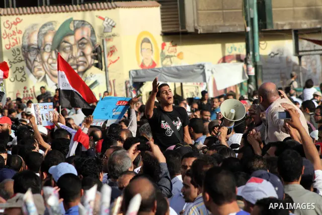 Egyptian protesters hold their national flag and effigies of the heads of former President Hosni Mubarak and his sons during a protest hours after the announcement of the verdict in their trial, in Tahrir square, Cairo,...