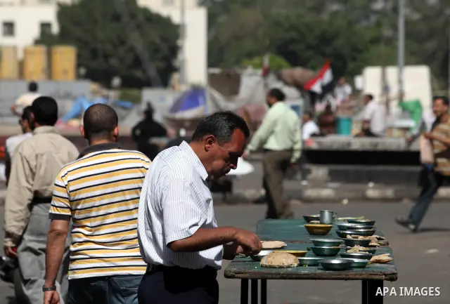 An Egyptian deals breakfast in Cairo's landmark Tahrir Square on June 3, 2012 after a night of protests. Hundreds of demonstrators are occupying Tahrir Square after a court sentenced ousted president Hosni Mubarak and hi...