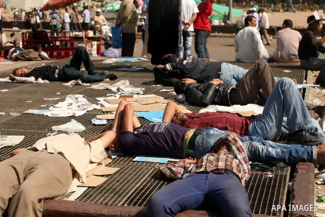 Egyptian men sleep on the ground in Cairo's landmark Tahrir Square on June 3, 2012 after a night of protests. Hundreds of demonstrators are occupying Tahrir Square after a court sentenced ousted president Hosni Mubarak a...