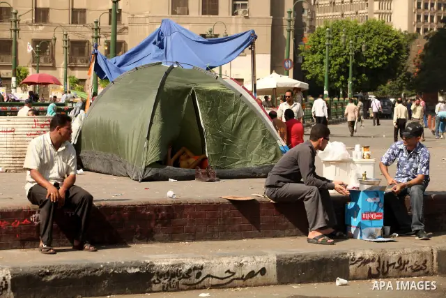 Egyptian men sleep on the ground in Cairo's landmark Tahrir Square on June 3, 2012 after a night of protests. Hundreds of demonstrators are occupying Tahrir Square after a court sentenced ousted president Hosni Mubarak a...