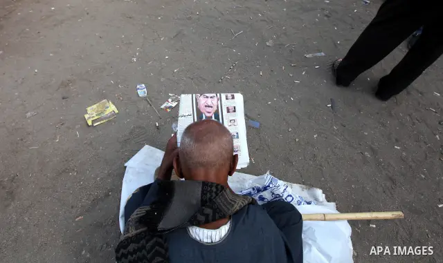 An Egyptian man read Egyptian newspapers in Cairo's landmark Tahrir Square on June 3, 2012 after a night of protests. Hundreds of demonstrators are occupying Tahrir Square after a court sentenced ousted president Hosni M...