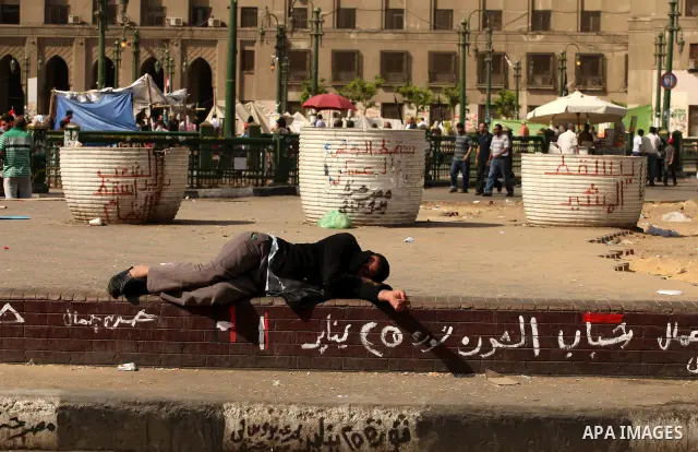 An Egyptian man sleeps on the ground in Cairo's landmark Tahrir Square on June 3, 2012 after a night of protests. Hundreds of demonstrators are occupying Tahrir Square after a court sentenced ousted president Hosni Mubar...