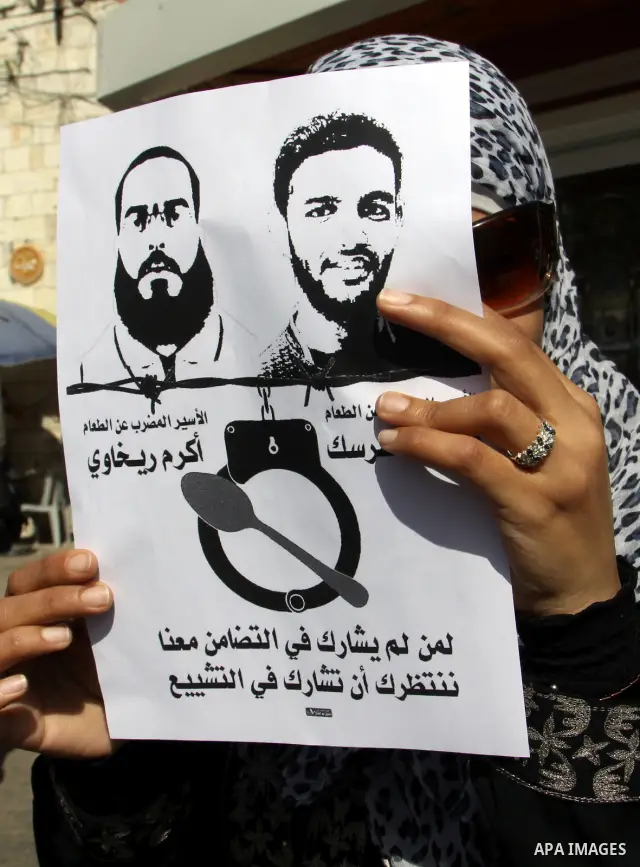 Palestinian protestors hold pictures of Palestinian prisoners Mahmoud al-Sarsak and Akram al-Rikhawi, whose are still refusing food for 80 days after a deal was made to end a mass prisoner hunger strike, during a demonst...