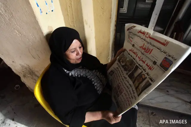 Egyptian woman reads a newspaper during a demonstration a day after a court sentenced deposed president Hosni Mubarak to life in prison, at Tahrir Square in Cairo June 3, 2012. Egyptian pro-democracy campaigners called f...