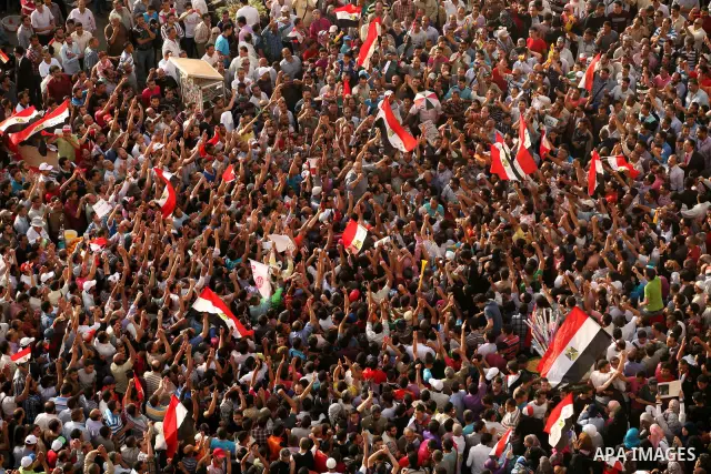 Egyptian preacher and member of the Muslim Brotherhood Safwat el-Hegazy is carried up by protesters as he joins them in a demonstration a day after a court sentenced deposed president Hosni Mubarak to life in prison, at...