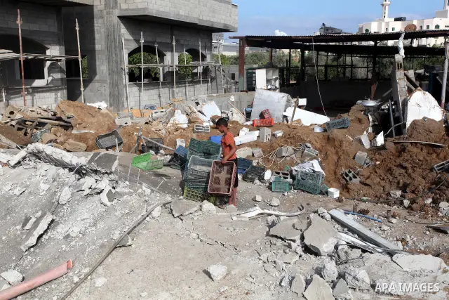 Palestinian boys inspect the damage at a cheese factory in Gaza City on June 4, 2012 following an Israeli air strike on the Gaza Strip on June 3. Emergency medical sources in Gaza said seven Palestinians were wounded in...