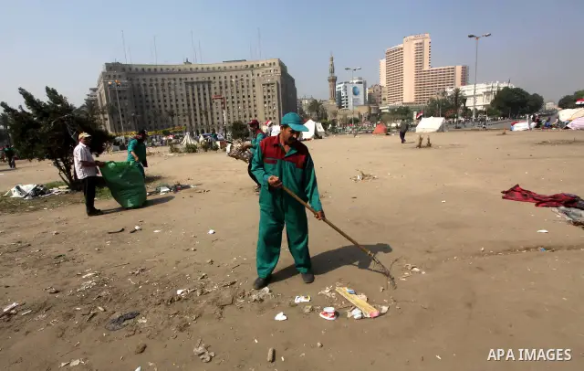 Men clear rubbish from a street during a sit-in at Tahrir Square, after a court sentenced deposed president Hosni Mubarak to life in prison in Cairo June 4, 2012. Egyptian pro-democracy campaigners called on Sunday for a...