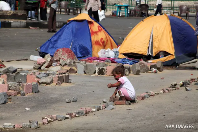 A Egyptian girl plays during a sit-in at Tahrir Square, after a court sentenced deposed president Hosni Mubarak to life in prison, in Cairo June 4, 2012. Thousands of Egyptians have taken to the streets in protest at the...