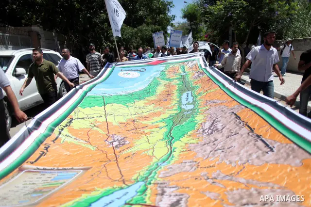 Palestinians hold a huge Palestine map, during the commemoration of the Naksa Day in Gaza City, June 5, 2012. Palestinians commemorate the Naksa Day, or the Setback, on Tuesday, marking the 45th anniversary of the Arabia...
