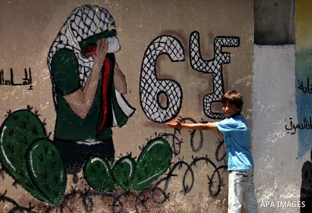 A Palestinian child stands in front of a mural during the commemoration of the Naksa Day in Gaza City, June 5, 2012. Palestinians commemorate the Naksa Day, or the Setback, on Tuesday, marking the 45th anniversary of the...
